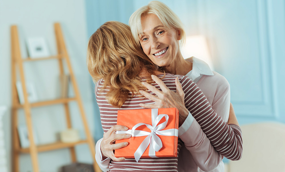 Senior mom giving gift to adult daughter