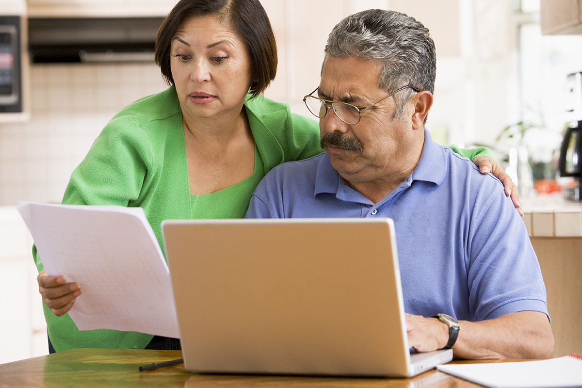 An older couple looking at their documents with confusion.