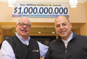 President Harald Borrmann and Senior Vice President Michael Ahles shake hands after announcing the company had reached $1 billion in assets on Nov. 11, 2019.