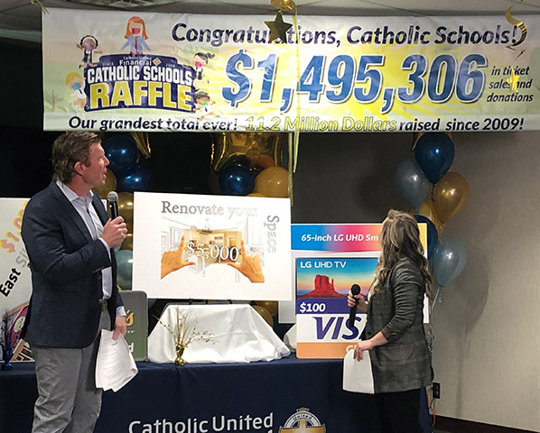 The banner is dropped and the 2021 Catholic Schools Raffle fundraising total is revealed, a new record for the program!