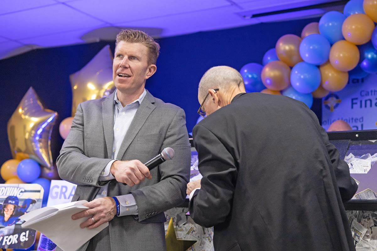 Prize Ceremony host Matt Birk entertains the crowd as The Most Rev. John LeVoir pulls winning tickets from the prize drum on March 10, 2022.